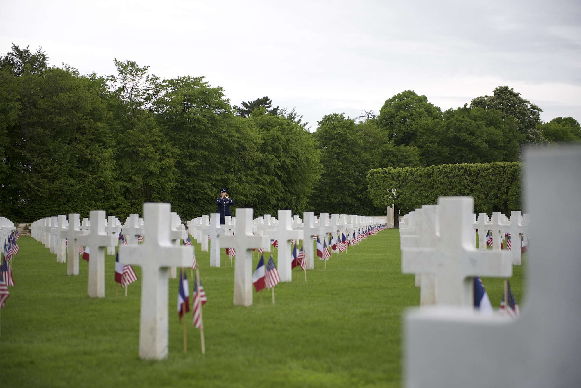 Technical Sergeant Jeffrey Reich with the U.S. Air Forces in Europe Band, plays taps preceding the raising of the colors. American and French citizens paid respects to World War I heroes during a remembrance ceremony at the Saint-Mihiel American Cemetery, May 22. (U.S. Air Force photo/Capt Chase P. McFarland/Released)