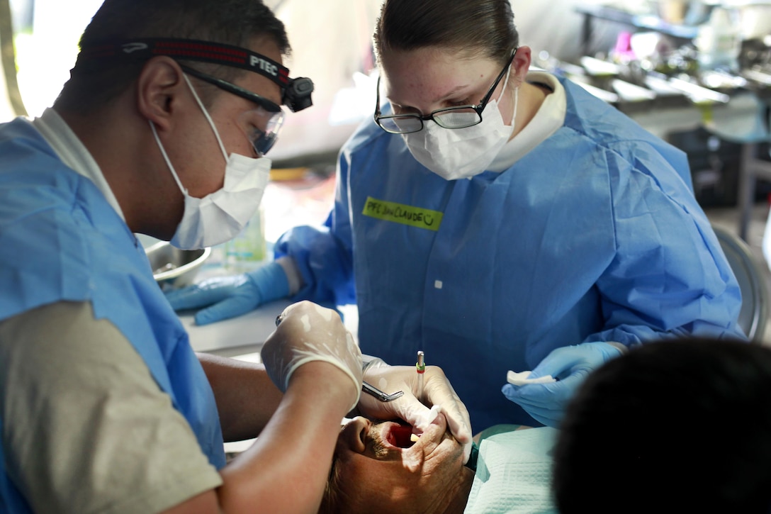 Army Maj. Jax Baylosis, left, and Army Pfc. Courtney JeanClaude extract a patient's tooth during Beyond the Horizon 2016 in San Padro, Guatemala, May 16, 2016. Baylosis is a dentist and JeanClaude is a dental assistant assigned to the 185th Dental Company. Army photo by Spc. Kelson Brooks