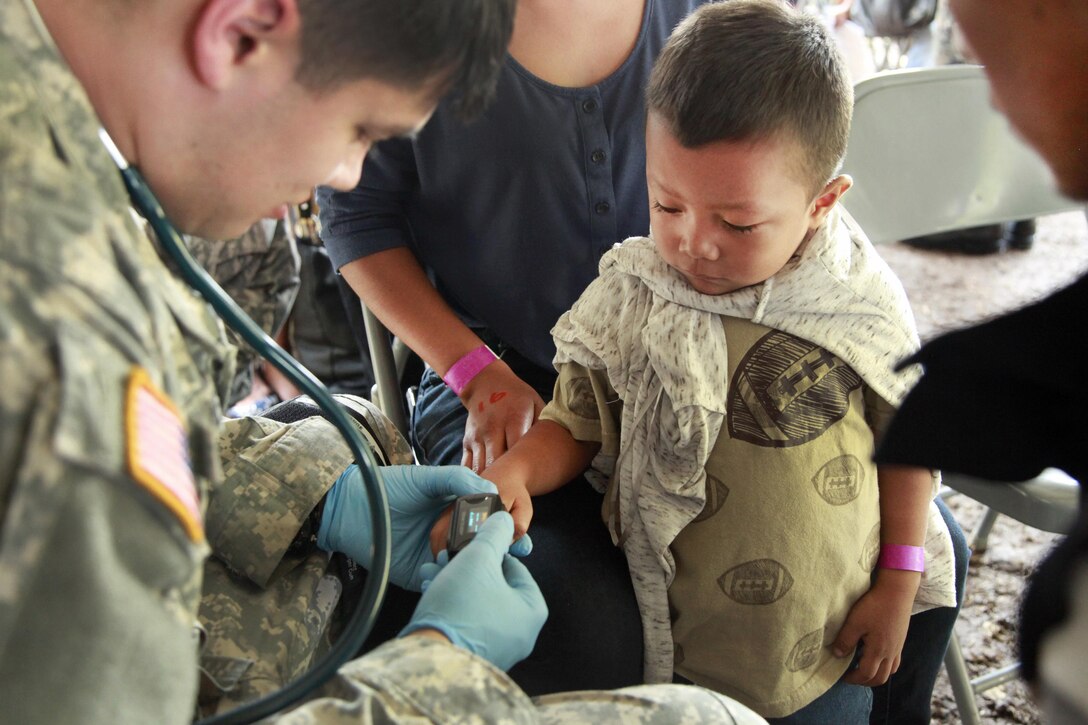 Army Spc. Joshua Towne, left, checks a patient's heart rate during Beyond the Horizon 2016 in San Padro, Guatemala, May 16, 2016. Towne is assigned to the 396th Combat Support Hospital Company. Army photo by Spc. Kelson Brooks