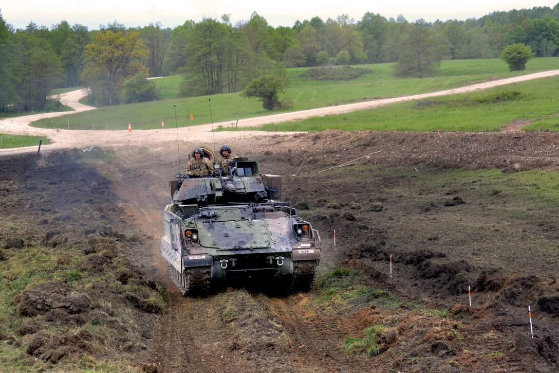 An M2A3 Bradley fighting vehicle crosses a field during a platoon’s Gunnery Table XII at Grafenwoehr Training Area, Germany, May 19, 2016. Army photo by Maj. Randy Ready