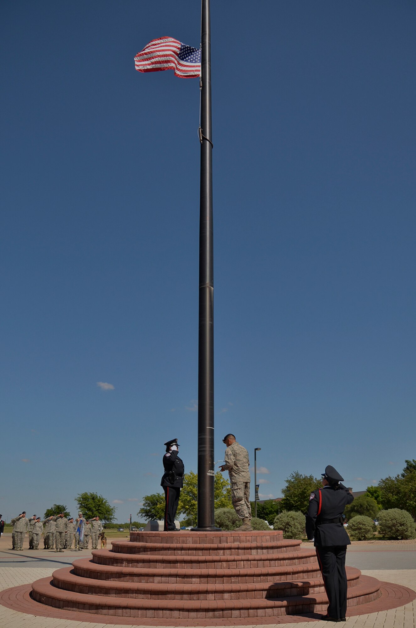 17th Security Forces Squadron Airmen and San Angelo law enforcement officers lower the nation’s flag on Goodfellow Air Force Base, Texas, May 20, 2016. The 17th SFS performed the ceremony to celebrate National Police Week, an annual event that honors all fallen police officers. (U.S. Air Force photo by Airman 1st Class Randall Moose/Released)