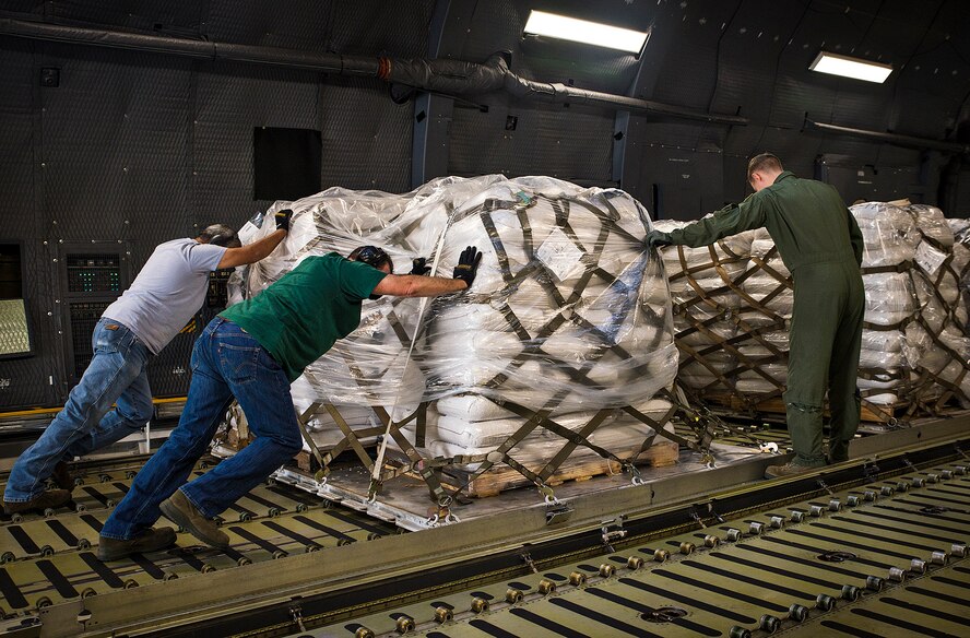 Airmen with the 356th Airlift Squadron and 502nd Logistics Readiness Squadron push pallets onto an awaiting C-5M Super Galaxy Aircraft May 13, 2016 at Joint Base San Antonio-Lackland, Texas. The 433rd Airlift Wing and 502nd LRS worked together to ensure 90,000 pounds of food aid made it to Yoro, Honduras. (U.S. Air Force photo by Benjamin Faske) (released)