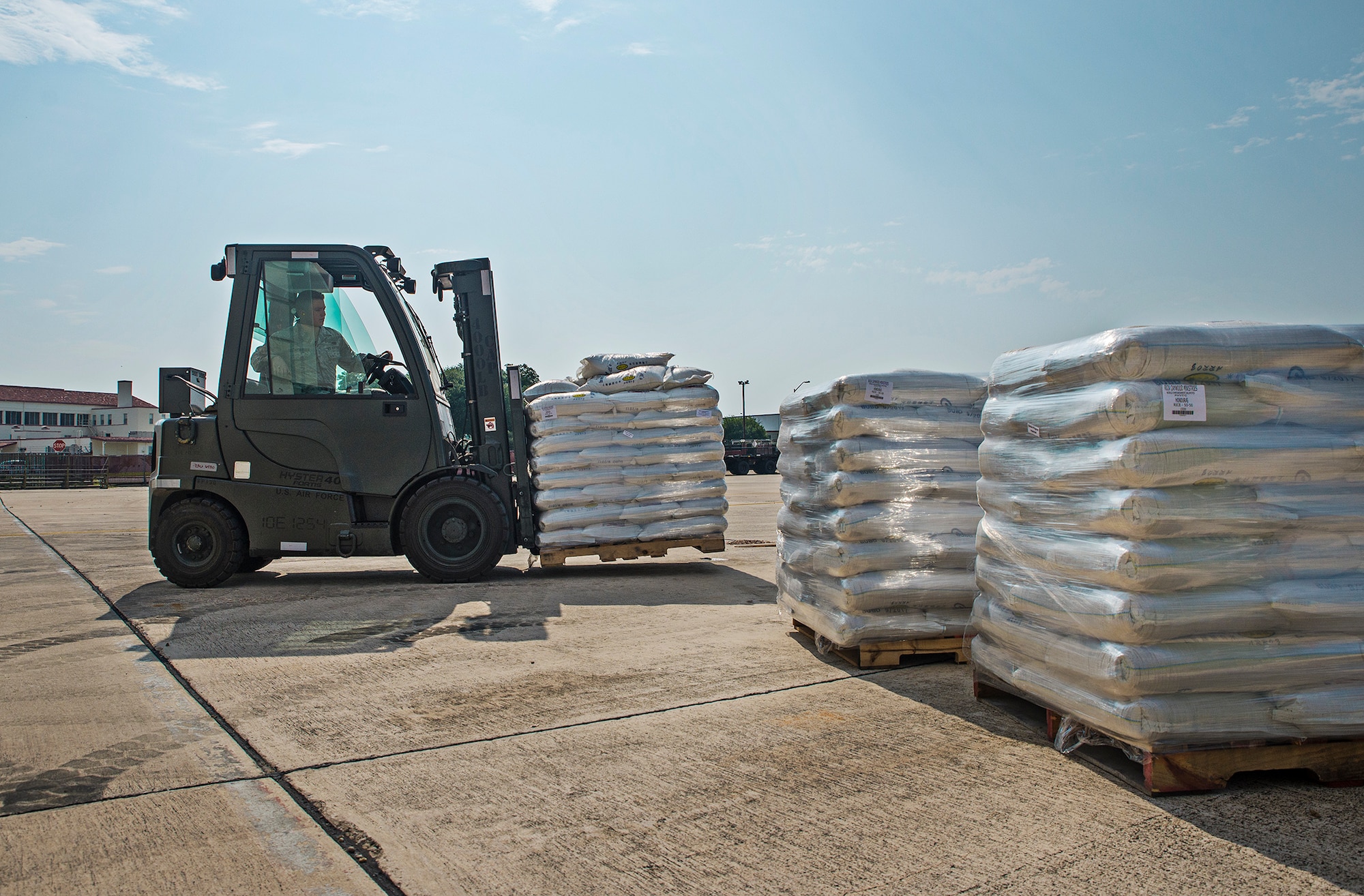 Airmen with the 502nd Logistics Readiness Squadron use a forklift to move pallets of rice and beans May 11, 2016 at Joint Base San Antonio-Lackland, Texas. The 433rd Airlift Wing and 502nd LRS worked together to palletize, load, and transport 90,000 pounds of food aid to Yoro, Honduras.  (U.S. Air Force photo by Benjamin Faske) 