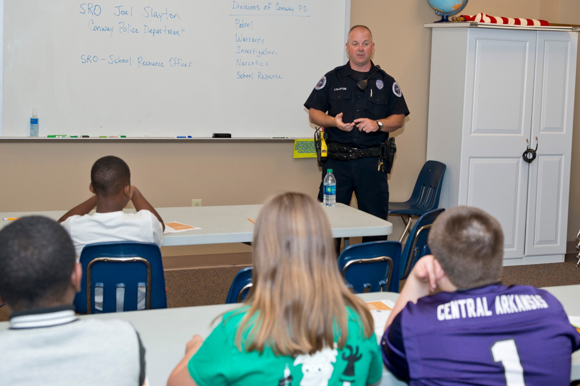 School Resource Officer Joel Slayton, Conway Police Department, briefs a group of students from Julia Lee Moore Elementary School, about a career as a law enforcement officer during the Fourth Grade Elementary Career Fair held at the Second Baptist Church in Conway Ark., May 17, 2016.  The event exposed more than 250 students to careers they might not have considered and the level of education those careers may require. (U.S. Air Force photo by Master Sgt. Jeff Walston/Released)  