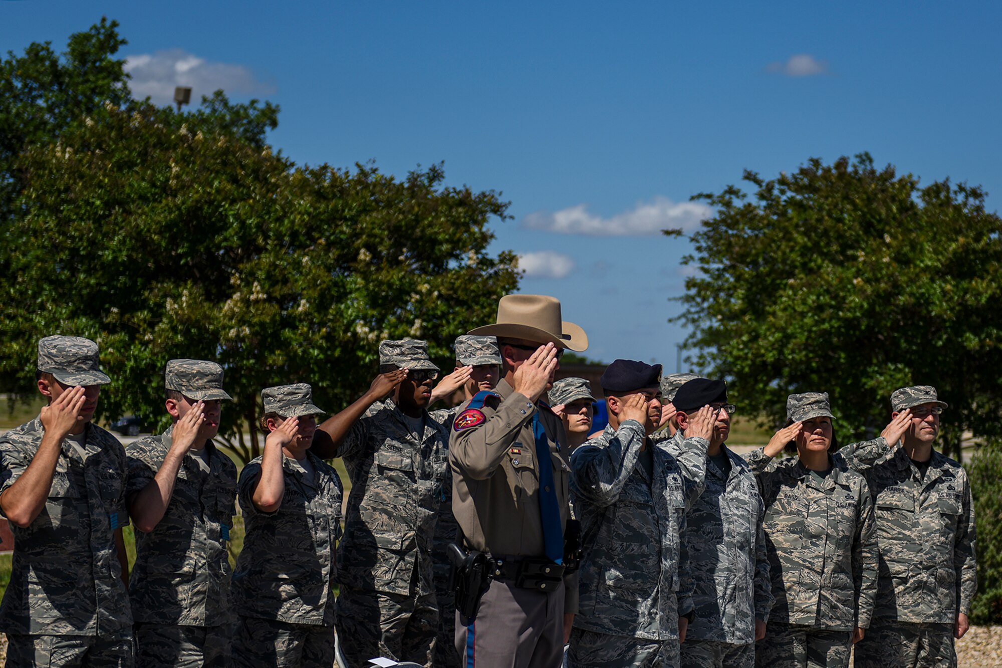 Members of the 17th Training Wing salute the nation’s flag as 17th Security Forces Squadron and San Angelo law enforcement officers lower it during a retreat ceremony at the Norma Brown Building on Goodfellow Air Force Base, Texas, May 20, 2016. The flag retreat ceremony honored fallen law enforcement officers as part of National Police Week. (U.S. Air Force photo by Senior Airman Devin Boyer/Released)
