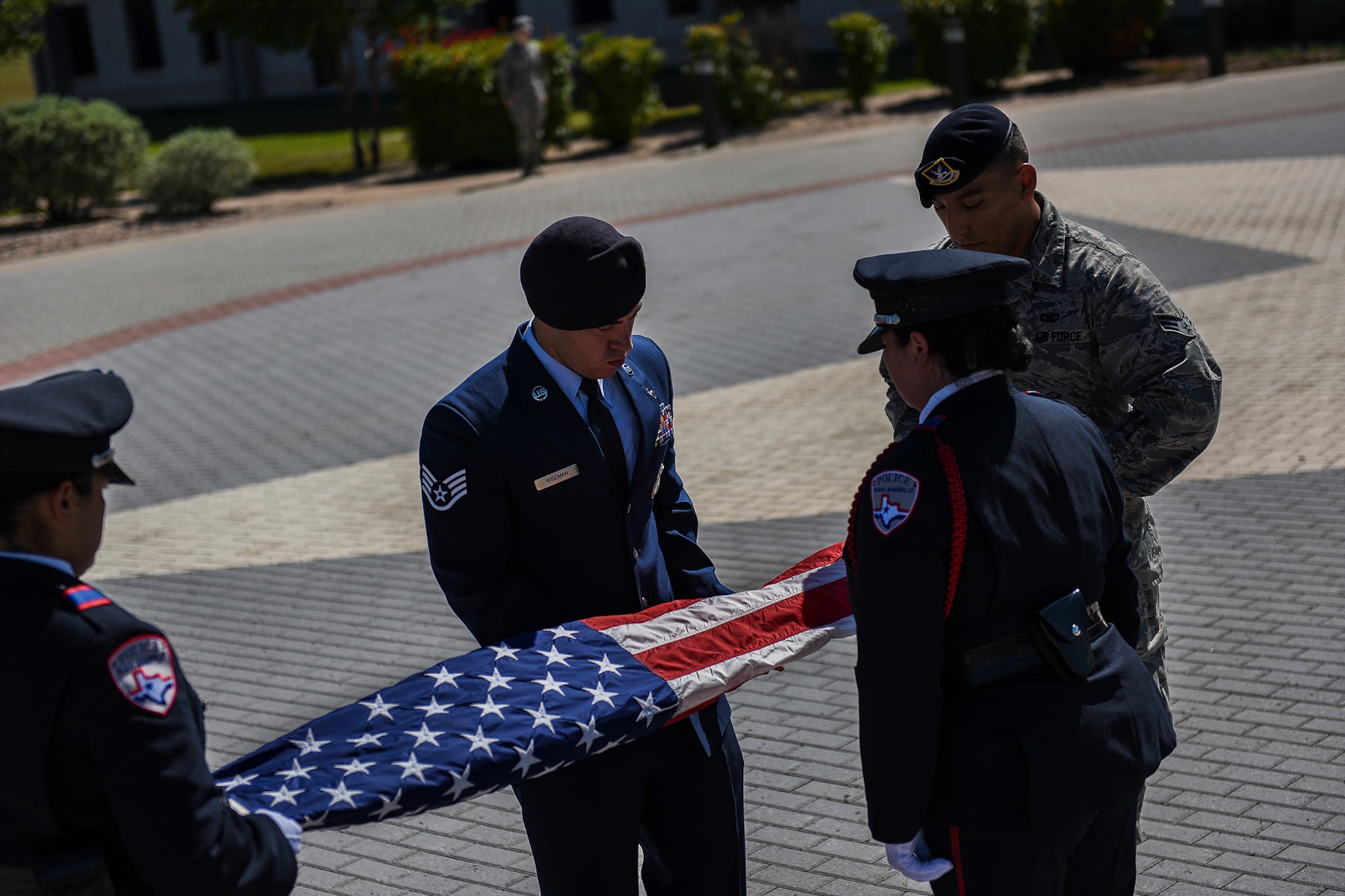 San Angelo and 17th Security Forces Squadron law enforcement officers fold the nation’s flag during a retreat ceremony for National Police Week at the Norma Brown Building on Goodfellow Air Force Base, Texas, May 20, 2016. Law enforcement officers from the community joined the 17th SFS Airmen to honor the men and women who paid the ultimate sacrifice in the line of duty. A retreat ceremony signals the end of the duty day and serves as a ceremony for paying respects to the flag. (U.S. Air Force photo by Senior Airman Devin Boyer/Released)