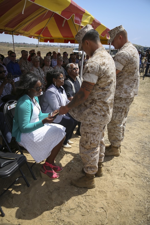 Stacia Harris, wife of Cpl. Larry Harris, displays the necklace that holds her husband’s wedding ring and dog tags after a dedication ceremony at Marine Corps Base Camp Pendleton, Calif., May. 19.  An obstacle of the Crucible was named after the Marine, who was killed in action on July 1, 2010.  His citation will be read every iteration of the Crucible, ensuring his heroics and legacy will never be forgotten.