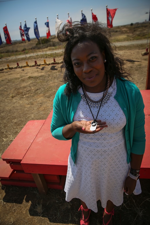 Stacia Harris, wife of Cpl. Larry Harris, displays the necklace that holds her husband’s wedding ring and dog tags after a dedication ceremony at Marine Corps Base Camp Pendleton, Calif., May. 19.  An obstacle of the Crucible was named after the Marine, who was killed in action on July 1, 2010.  His citation will be read every iteration of the Crucible, ensuring his heroics and legacy will never be forgotten.