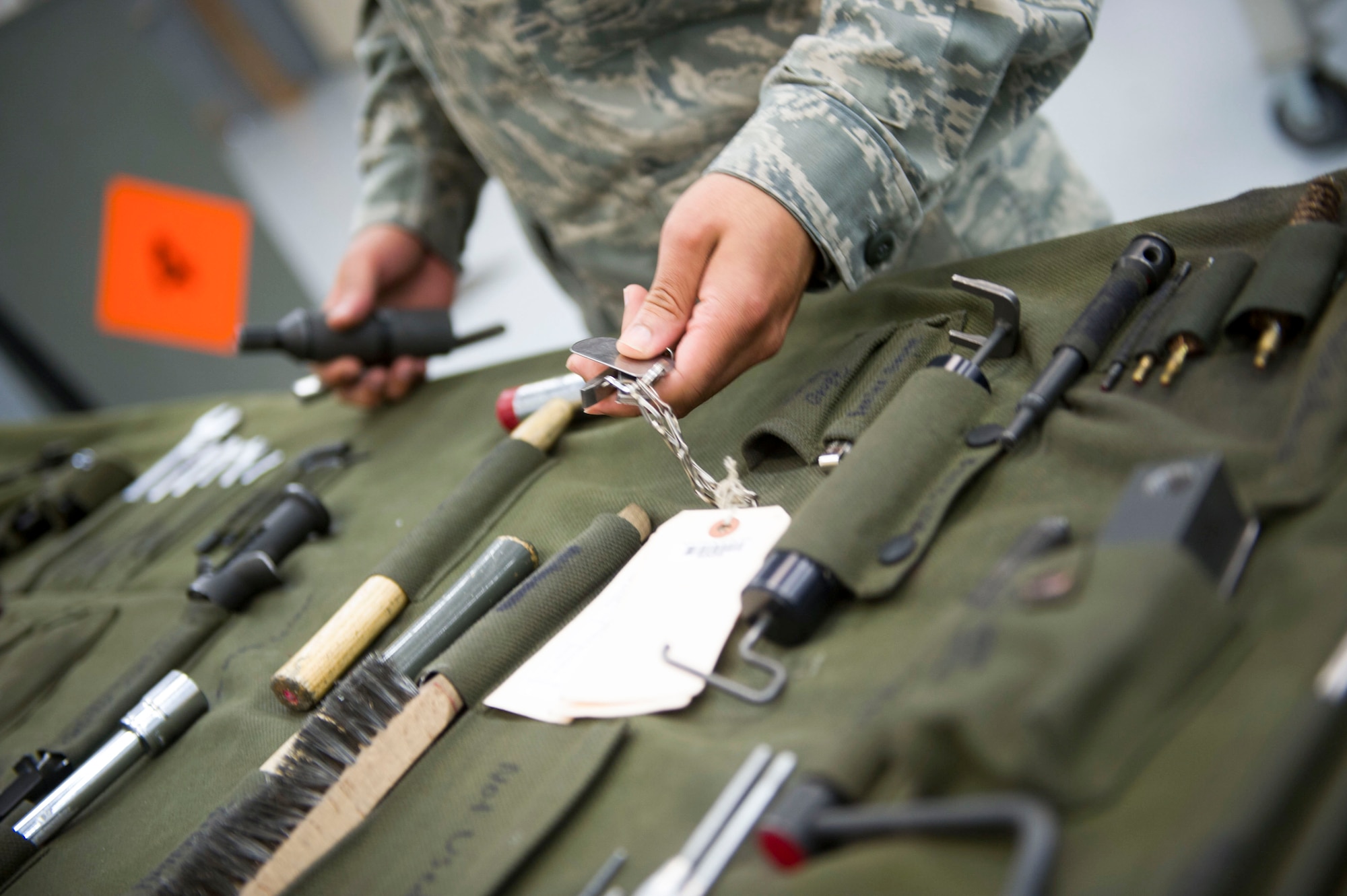 Senior Airman Benjamin DeLone, a weapons load crew journeyman with the 801st Special Operations Aircraft Maintenance Squadron, grabs tools needed to perform a 28-day inspection on a 50-caliber machine gun at Hurlburt Field, Fla, May 17, 2016. The inspections are performed as preventive maintenance. (U.S. Air Force photo by Senior Airman Krystal M. Garrett)