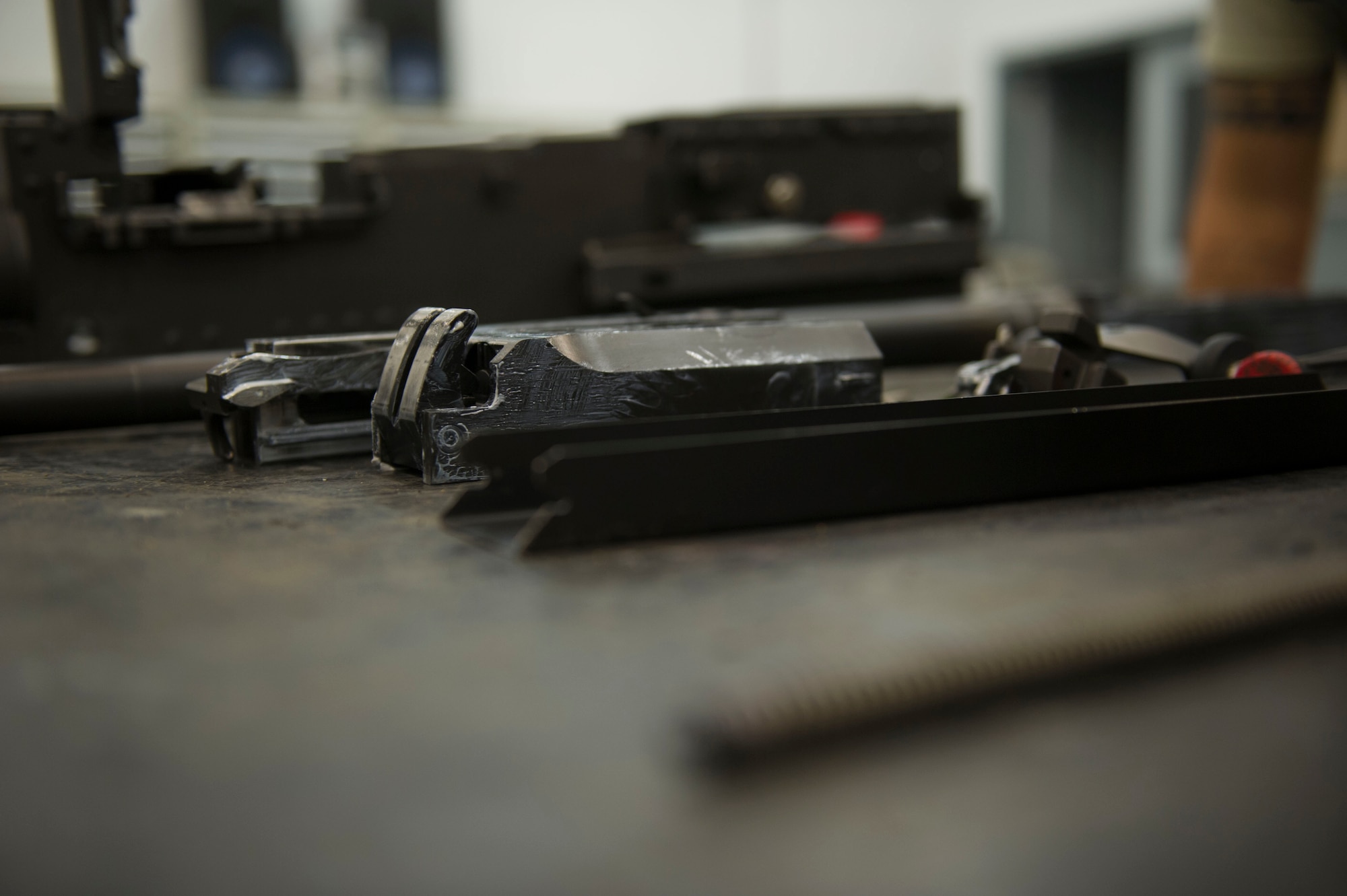 Parts of a 50-caliber machine gun lay on a table after being taken apart and lubricated at Hurlburt Field, Fla., May 17, 2016. Every 28 days the weapons systems are taken apart, checked, lubricated and put back together. (U.S. Air Force photo by Senior Airman Krystal M. Garrett) 