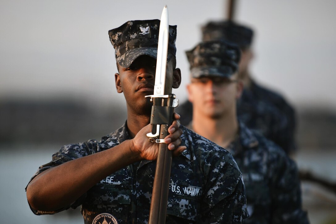 Navy Petty Officer 3rd Class Ivan Lee, foreground, a member of the Navy Ceremonial Guard Drill Team, participates in training with fellow team members outside the guard's facility at Joint Base Anacostia-Bolling in Washington, D.C., May 19, 2016. Air National Guard photo by Staff Sgt. Christopher S. Muncy