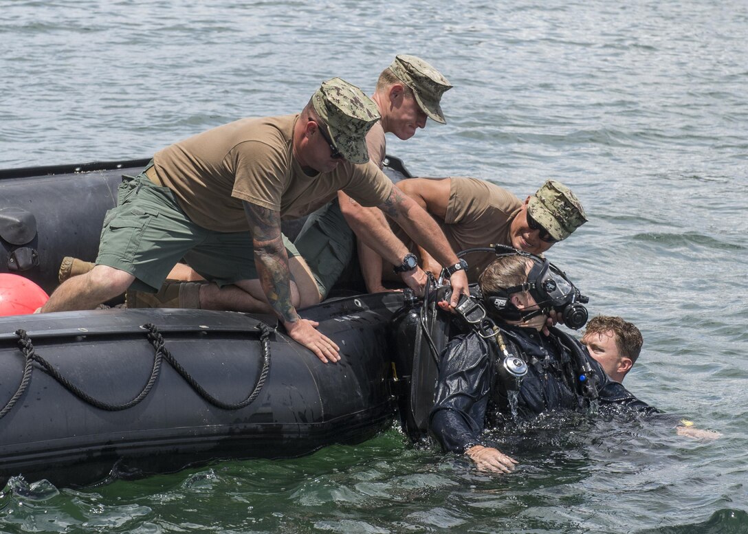 Seabee divers pull Navy Petty Officer 2nd Class Justin Lieder out of the water during an unconscious diver drill at Naval Inactive Ship Maintenance Facility at Pearl Harbor, Hawaii, May18, 2016. The divers are assigned to Underwater Construction Team 2, Construction Dive Detachment Alpha, which provides responsive inshore and underwater construction capabilities. Navy photo by Petty Officer 1st Class Charles E. White