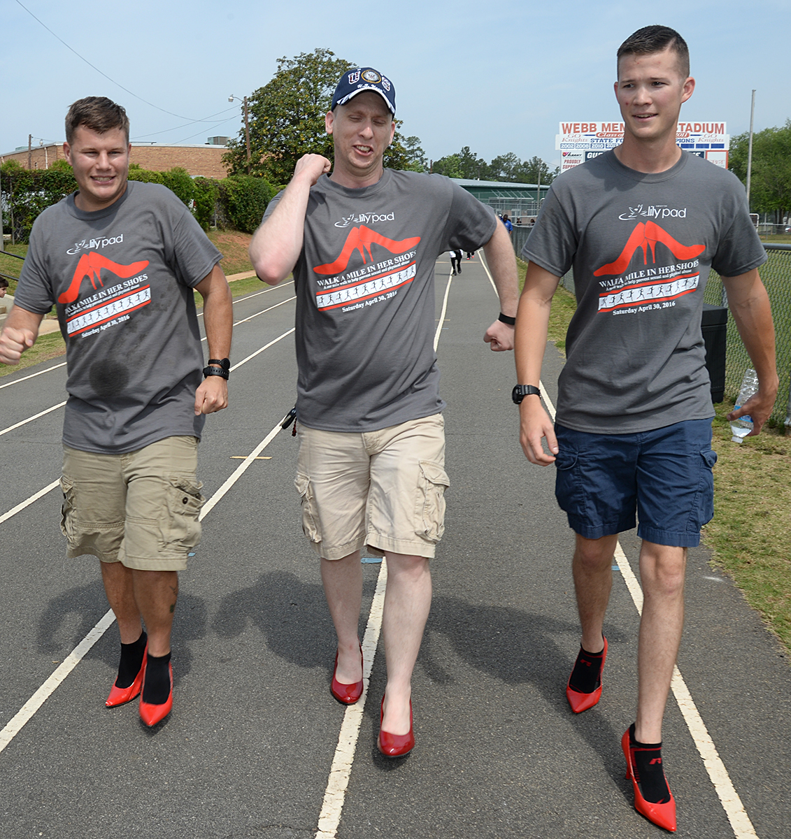 (Left to right) Petty Officer 2nd Class Perry Davis, Petty Officer 2nd Class Kurtis Glenn and Petty Officer 3rd Class Benjamin Rozeboom, Naval Branch Health Clinic-Albany, make their way around the track wearing red high-heeled shoes.  The Sailors participated in the Walk a Mile in Her Shoes event benefitting Lily Pad at Deerfield-Windsor School’s Webb Memorial Stadium in Albany, Ga., recently.
