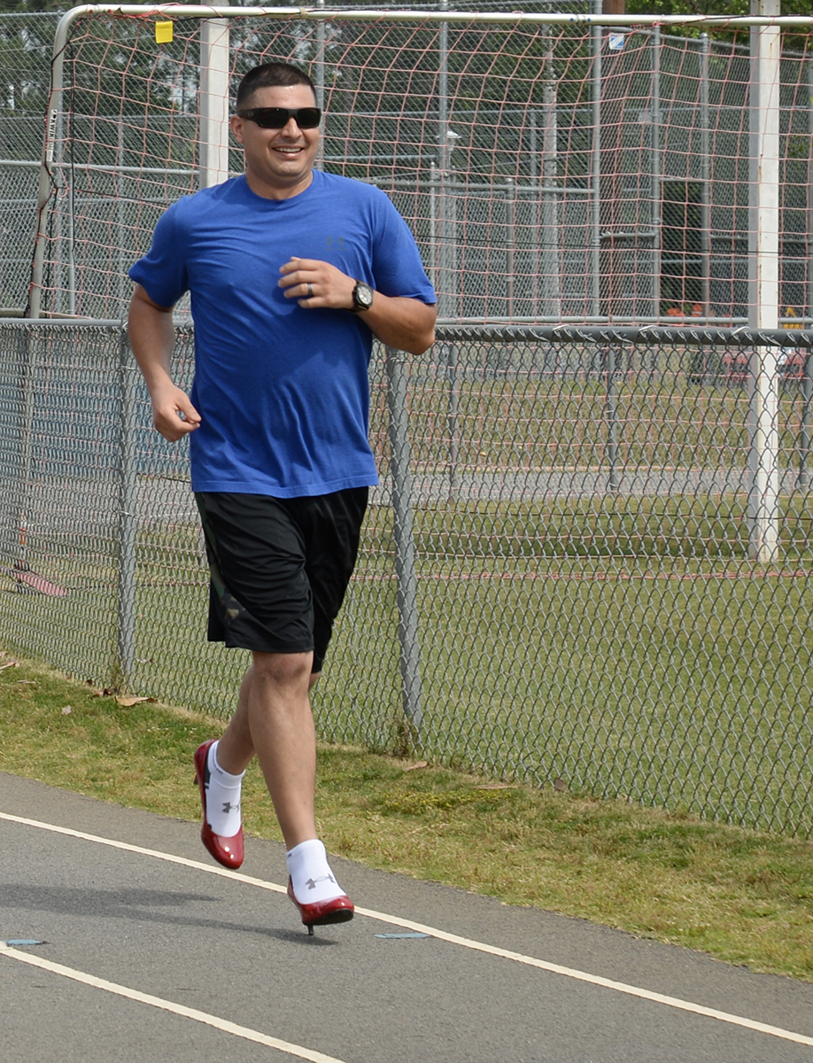 Maj. Frank Sierra, information solution architect, Command, Control, Communications and Computers Department, Marine Corps Logistics Command, runs one of four laps around the track in heels to support the Lily Pad’s Walk a Mile in Her Shoes event at Deerfield-Windsor School’s Webb Memorial Stadium in Albany, Ga., recently.