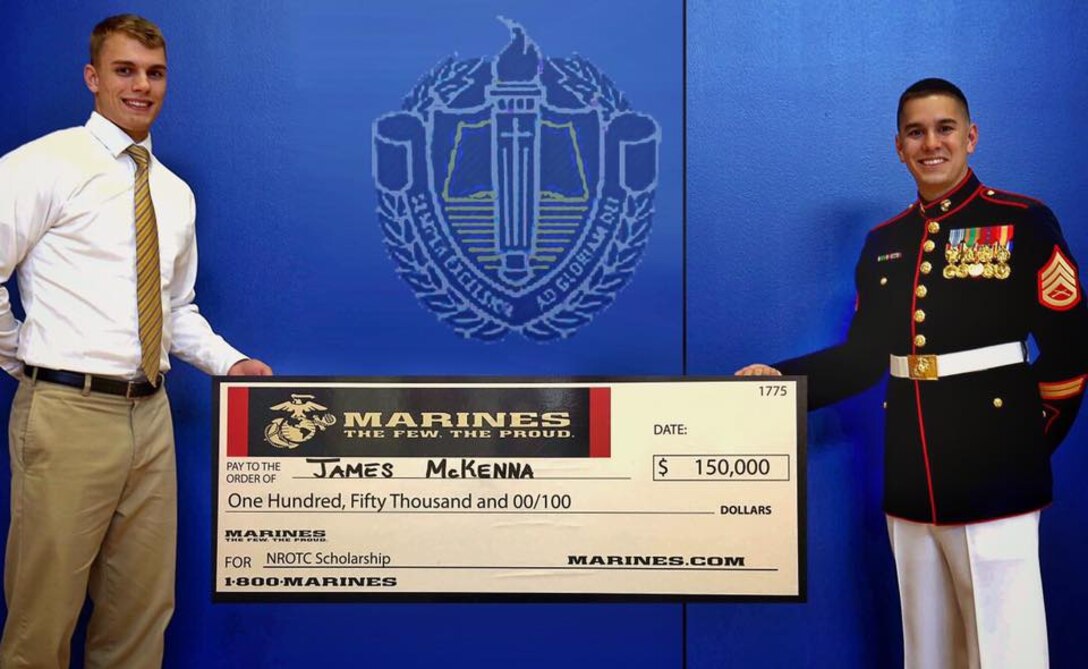 Staff Sgt. Michael Butler presents James McKenna with a Naval Reserve Officer Training Corps Scholarship check during a special high school assembly in Spring, Texas., June 9, 2016. Butler is a recruiter with Recruiting Substation Spring, Marine Corps Recruiting Station Houston. McKenna is a senior at Providence Classical High School and a Spring, Texas native.  

