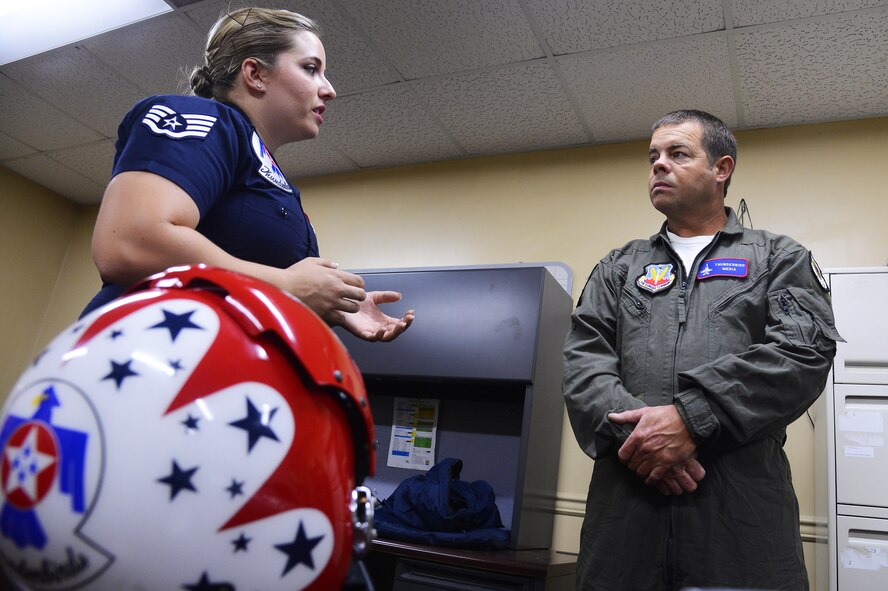 U.S. Air Force Staff Sgt. Madeline Davis, U.S. Air Force Air Demonstration Squadron aircrew flight equipment specialist, teaches Christopher Geddings, Sumter City fire department engineer, about the flight helmet issued to him before his hometown hero flight at Shaw Air Force Base, S.C., May 20, 2016. The Thunderbirds flew Geddings as part of their hometown hero program, which recognizes local civilians for their dedication to their communities. (U.S. Air Force photo by Senior Airman Jonathan Bass)