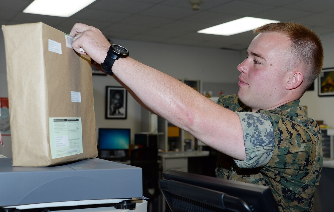 Staff Sgt. Steven McGahee, postal clerk, Marine Corps Logistics Base Albany, labels a package at the installation’s mailroom, May 12. McGahee was meritoriously promoted to his current rank recently after winning the final meritorious promotion board at Marine Corps Installations Command.