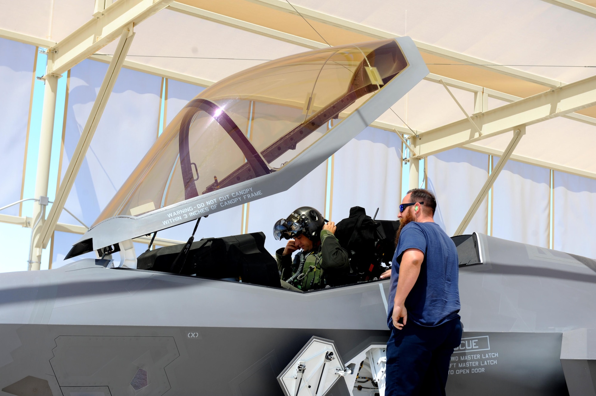 Lt. Col. Gregory Frana, 62nd Fighter Squadron commander, prepares to remove his helmet May 19, 2016, at Luke Air Force Base after flying Luke's 5000th F-35 sortie. Paul Linski, 62nd Aircraft Maintenance Unit Lockheed Martin
crew chief, stands by to assist Frana in safely removing his gear and exiting the jet. (U.S. Air Force photo by Airman 1st Class Pedro Mota)