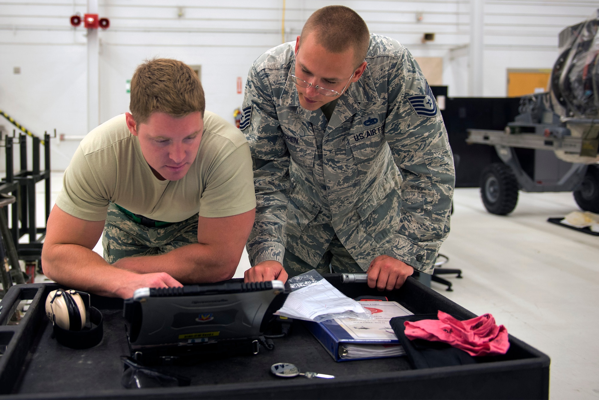 U.S. Air Force Staff Sgt. Kyle Carter, 23d Component Maintenance Squadron TF-34 jet engine intermediate maintenance dock chief, left, and Tech. Sgt. Matthew Cohen, 23d Maintenance Group quality assurance inspector, review task data on a TF-34 jet engine technical order during an inspection, May 24, 2016, at Moody Air Force Base, Ga. Before the engine reaches ‘war-ready’ status, it must process through two phases consisting of a physical inspection and documentation that matches and complies with the Integrated Maintenance Data System. 
(U.S. Air Force photo by Airman 1st Class Greg Nash/Released)  
