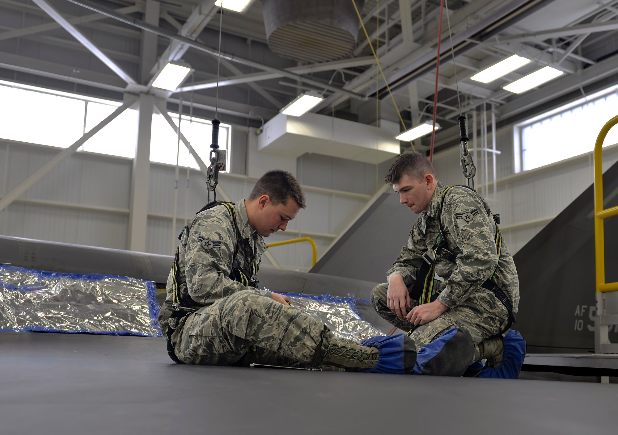 Airman 1st Class Griffin Smith and Airman 1st Class William Manion, 33rd Maintenance Squadron aircraft fuels system repairmen apprentices, gather tools to perform maintenance on an F-35A Lightning II panel at Eglin Air Force Base, Fla., Jan. 13, 2016. Fuel systems Airmen maintain fuel tanks and cells by removing, repairing and replacing malfunctioning components. (U.S. Air Force Photo/Senior Airman Andrea Posey)