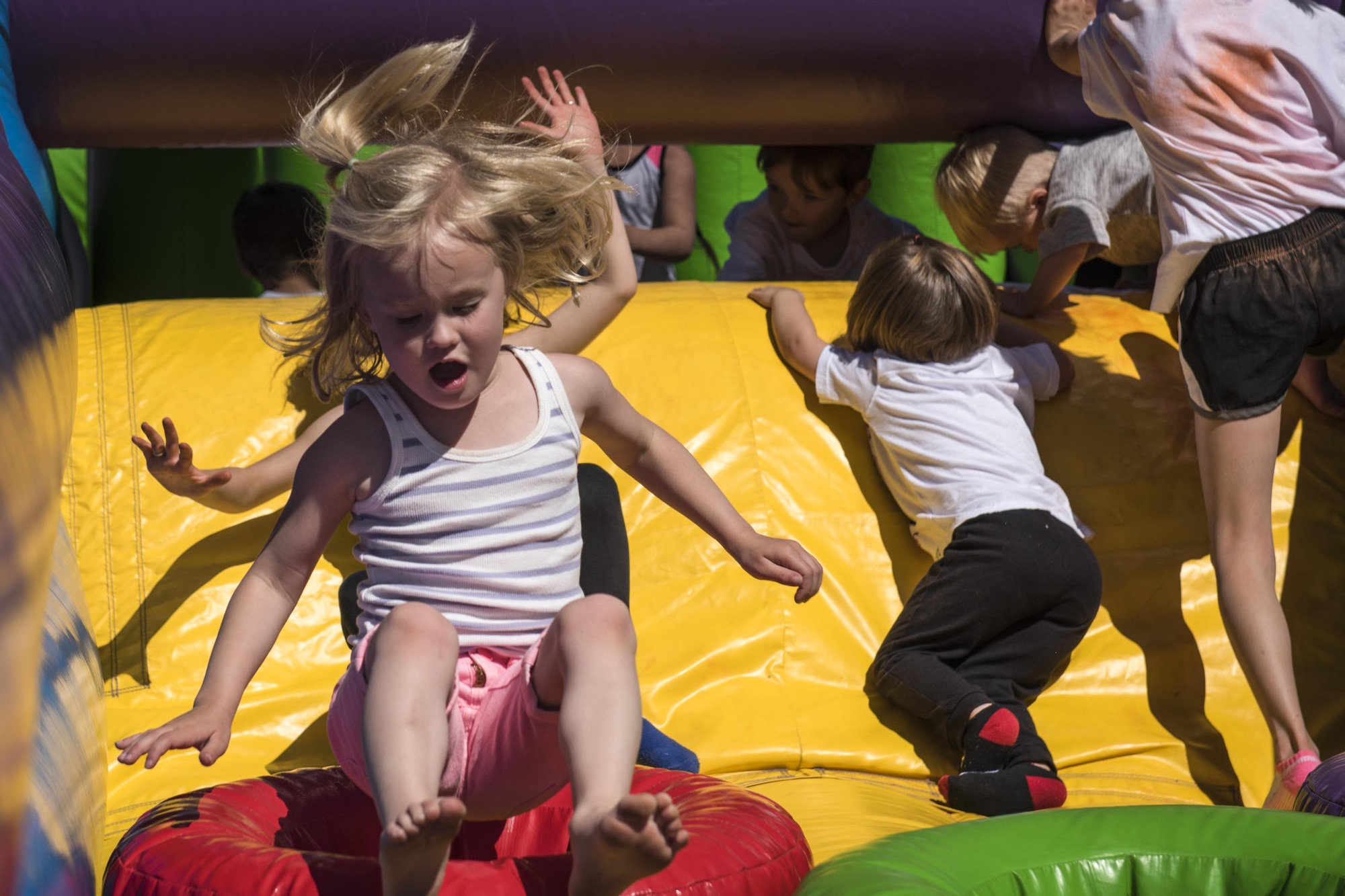 Meika Barker bounces on an inflatable obstacle at the Kickoff to Summer event held May 21, 2016 at Peterson Air Force Base’s Outdoor Recreation. The event provided fun family activities, like a color run, bounce castles, music, a bike rodeo, food and more to begin the summer season. (U.S. Air Force photo by Senior Airman Rose Gudex)