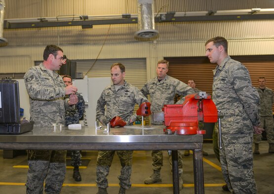 Staff Sgt. Webb Travis, 33rd Maintenance Squadron metals technician craftsman, shows Col. Robert Kiebler, 49th Wing commander, examples of innovative tools created by metals technicians at Eglin Air Force Base (AFB), Fla., Jan. 15, 2016. Innovations such as these locally crafted throttle covers and stiffener brackets have saved the Air Force close to $84,000. (U.S. Air Force Photo/Senior Airman Andrea Posey)