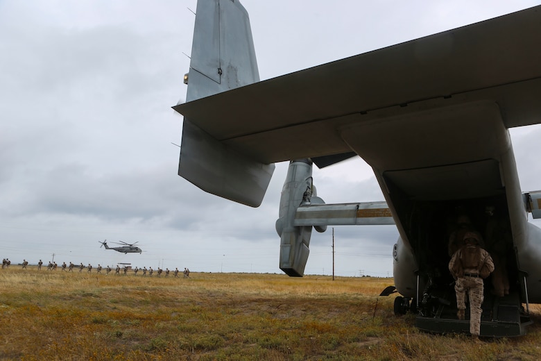 Marines with the 11th Marine Expeditionary Unit board an MV-22B Osprey and wait to board a CH-53E Super Stallion with Marine Medium Tiltrotor Squadron (VMM) 163 (Reinforced) during a simulated raid on Marine Corps Base Camp Pendleton, Calif., May 17. Marines with VMM-163 (Rein.) supplied four MV-22B Ospreys, two AH-1W Cobras, two UH-1Y Hueys and one CH-53E Super Stallion to support a simulated raid. (U.S. Marine Corps photo by Lance Cpl. Harley Robinson/Released)