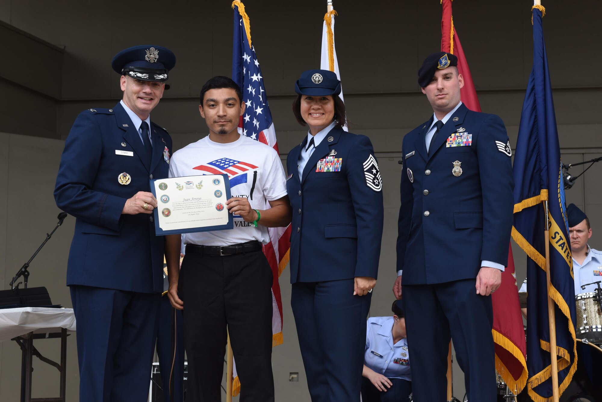 U.S. Air Force Col. Michael Downs, 17th Training Wing Commander, presents a certificate to Juan Arroyo, high school student, for choosing to enlist in the Air Force, at the RiverStage in San Angelo, Texas, May 21, 2016. (U.S. Air Force photo by Airman 1st Class Chase Sousa/Released)