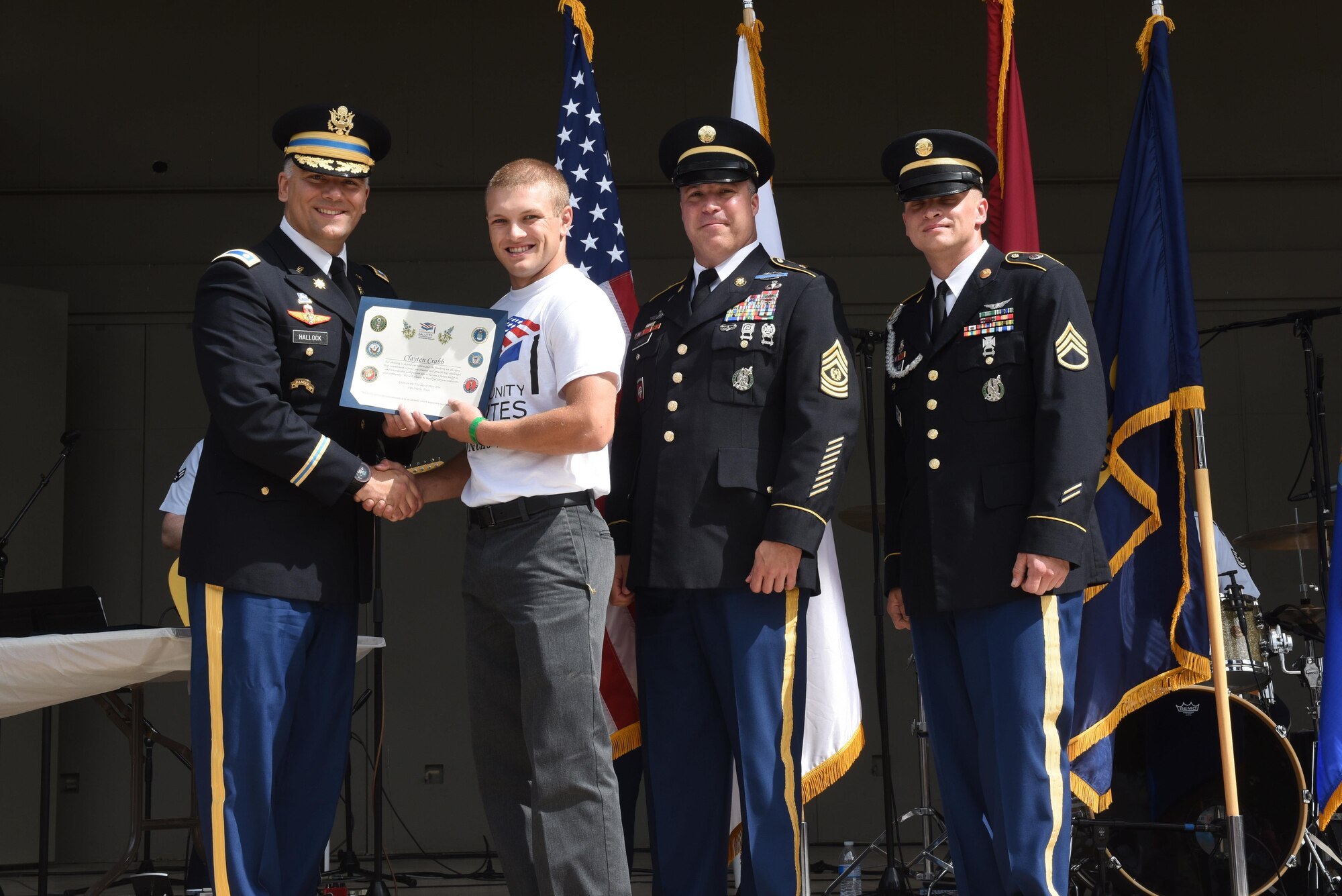 U.S. Army Lt. Col. Jason Hallock, 344th Military Intelligence Battalion Commander, presents a certificate to Clayten Crabb, high school student, for choosing to enlist in the Army, at the RiverStage in San Angelo, Texas, May 21, 2016. (U.S. Air Force photo by Airman 1st Class Chase Sousa/Released)