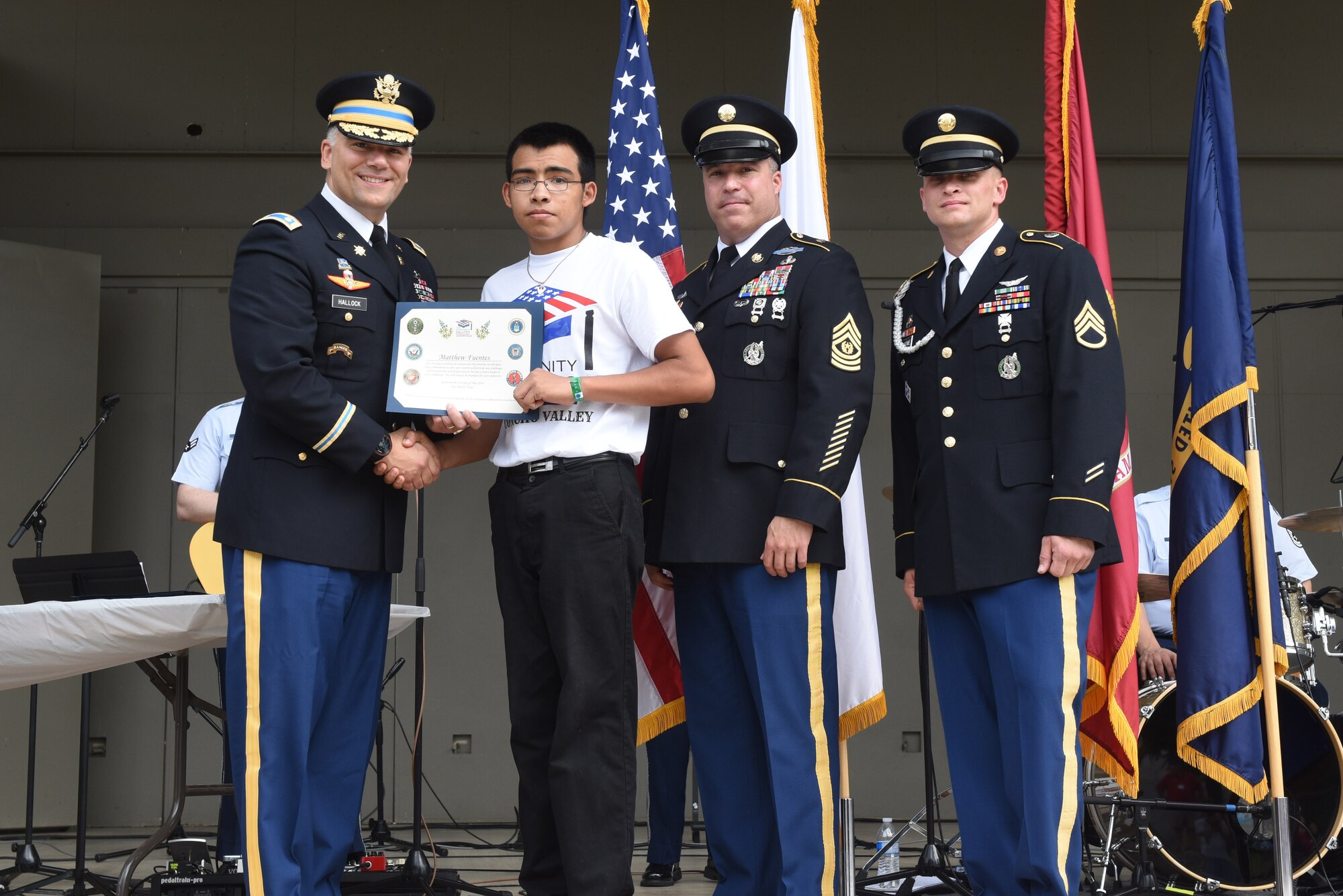 U.S. Army Lt. Col. Jason Hallock, 344th Military Intelligence Battalion Commander, presents a certificate to Matthew Fuentes, high school student, for choosing to enlist in the Army, at the RiverStage in San Angelo, Texas, May 21, 2016. (U.S. Air Force photo by Airman 1st Class Chase Sousa/Released)