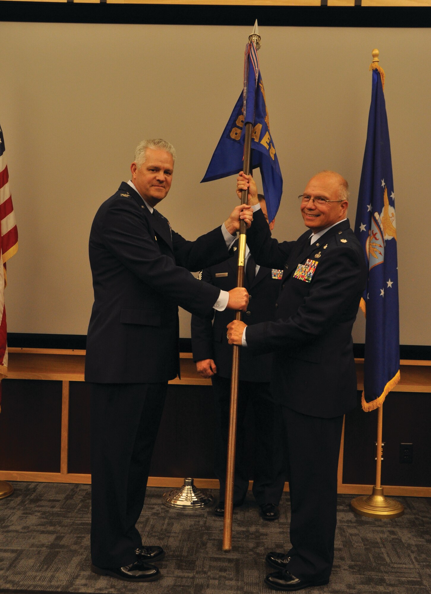 Col. Donald Richey, 908th Operations Group Commander, passes the 908th Aeromedical Evacuation Squadron guidon to Lt. Col. Mike Hilyard, signifying his assumption of command. (U.S. Air Force photo by Andrew Stamer)