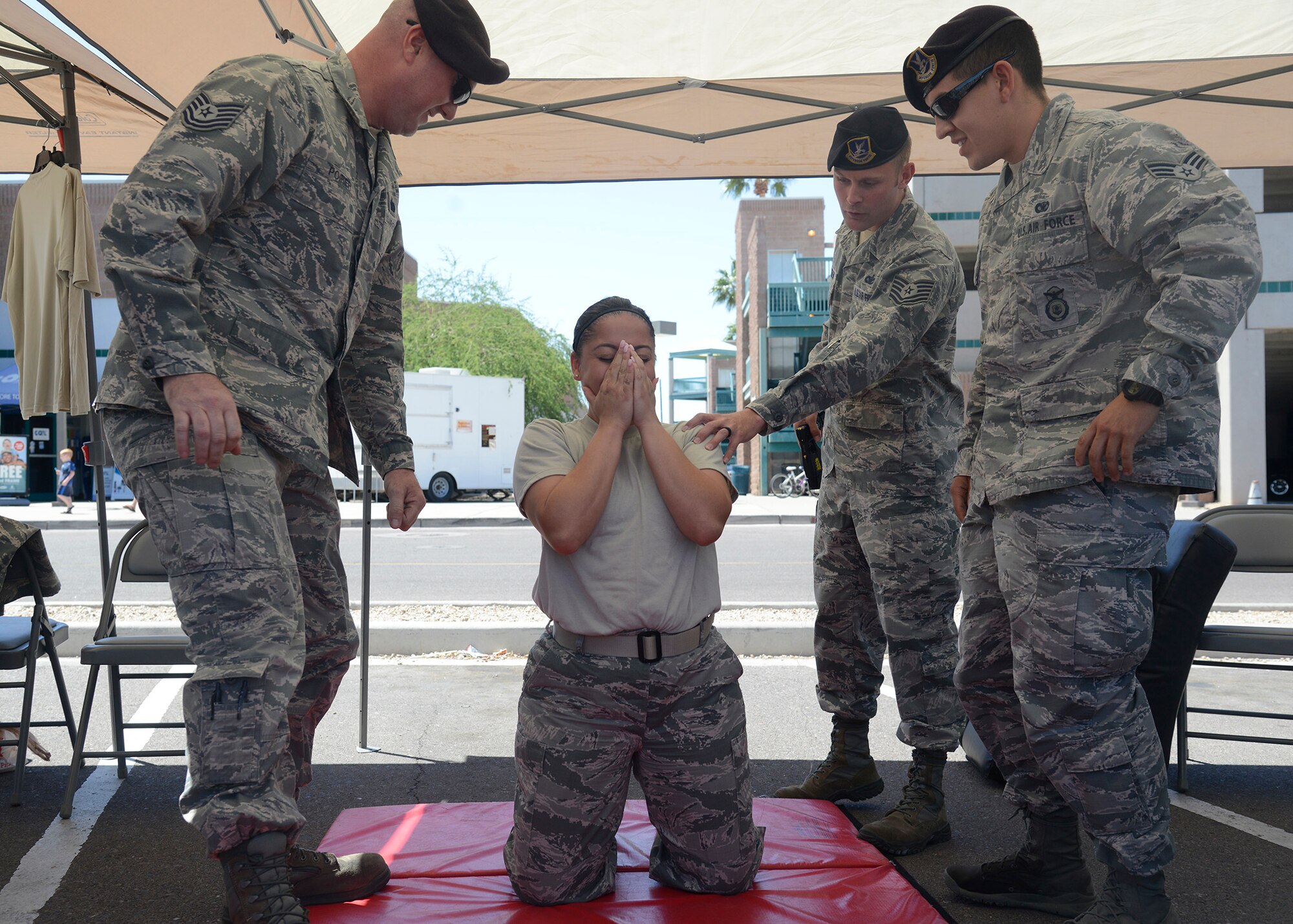 Members of the 56th Security Forces Squadron check on Staff Sgt. Melissa Cooper, 56th Civil Engineer Squadron unit training manager, after being tased during the opening day of Police Week May 16, 2016 at Luke Air Force Base, Ariz. The demonstration was part of Police Week, in which volunteers got a chance to experience how SFS personnel use tasers to stop suspects. (U.S. Air Force photo by Senior Airman Devante Williams)