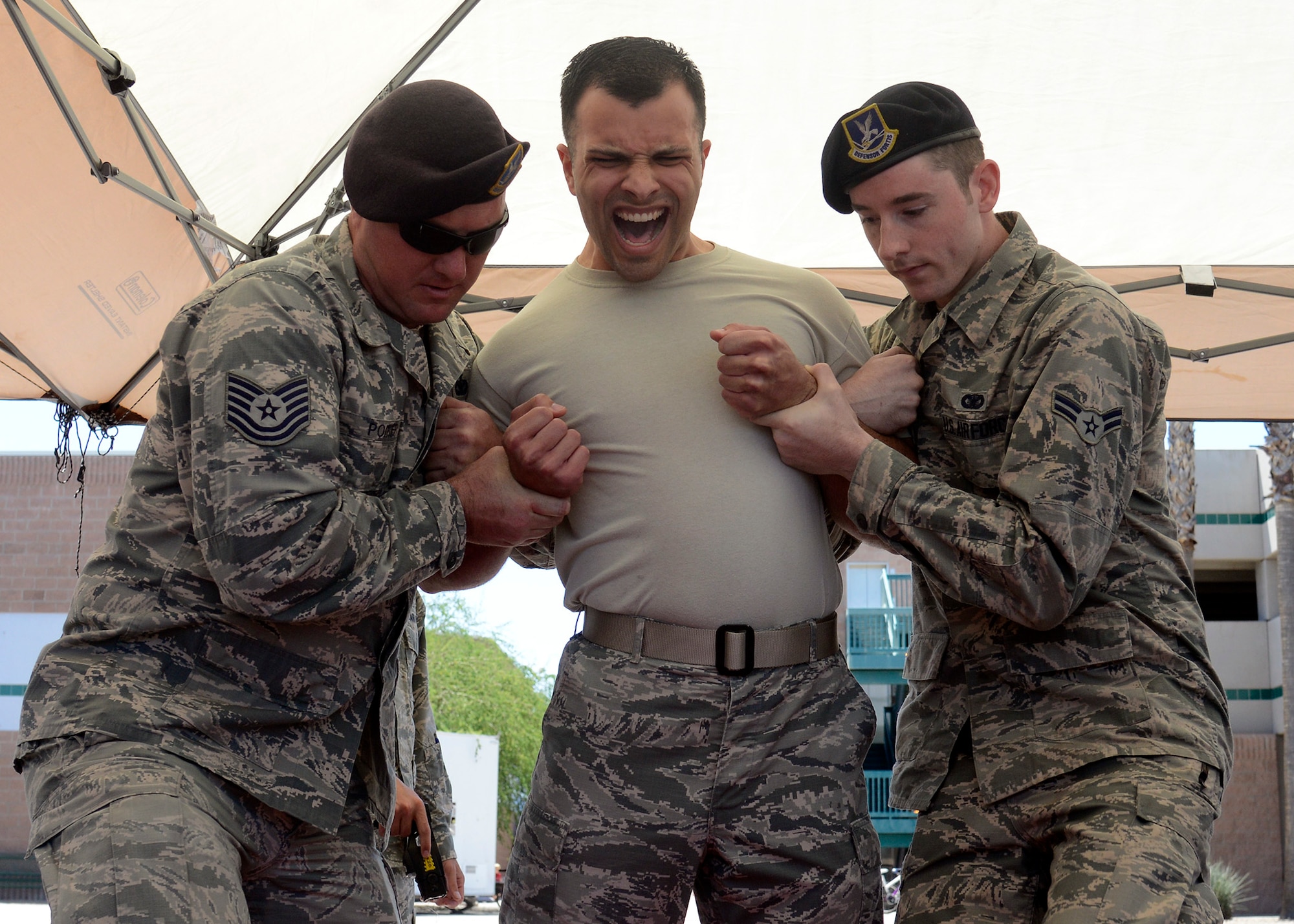 Members of the 56th Security Forces Squadron hold Staff Sgt. Jonathan Mahlan, 756th Aircraft Maintenance Squadron lead crew member, as he is tased during the opening day of Police Week May 16, 2016 at Luke Air Force Base, Ariz.  The 56th Security Forces Squadron teamed up with the Phoenix, Glendale, and Buckeye police departments to celebrate National Police Week. Police week is designed to show respect for officers who have given the ultimate sacrifice. (U.S. Air Force photo by Senior Airman Devante Williams)
