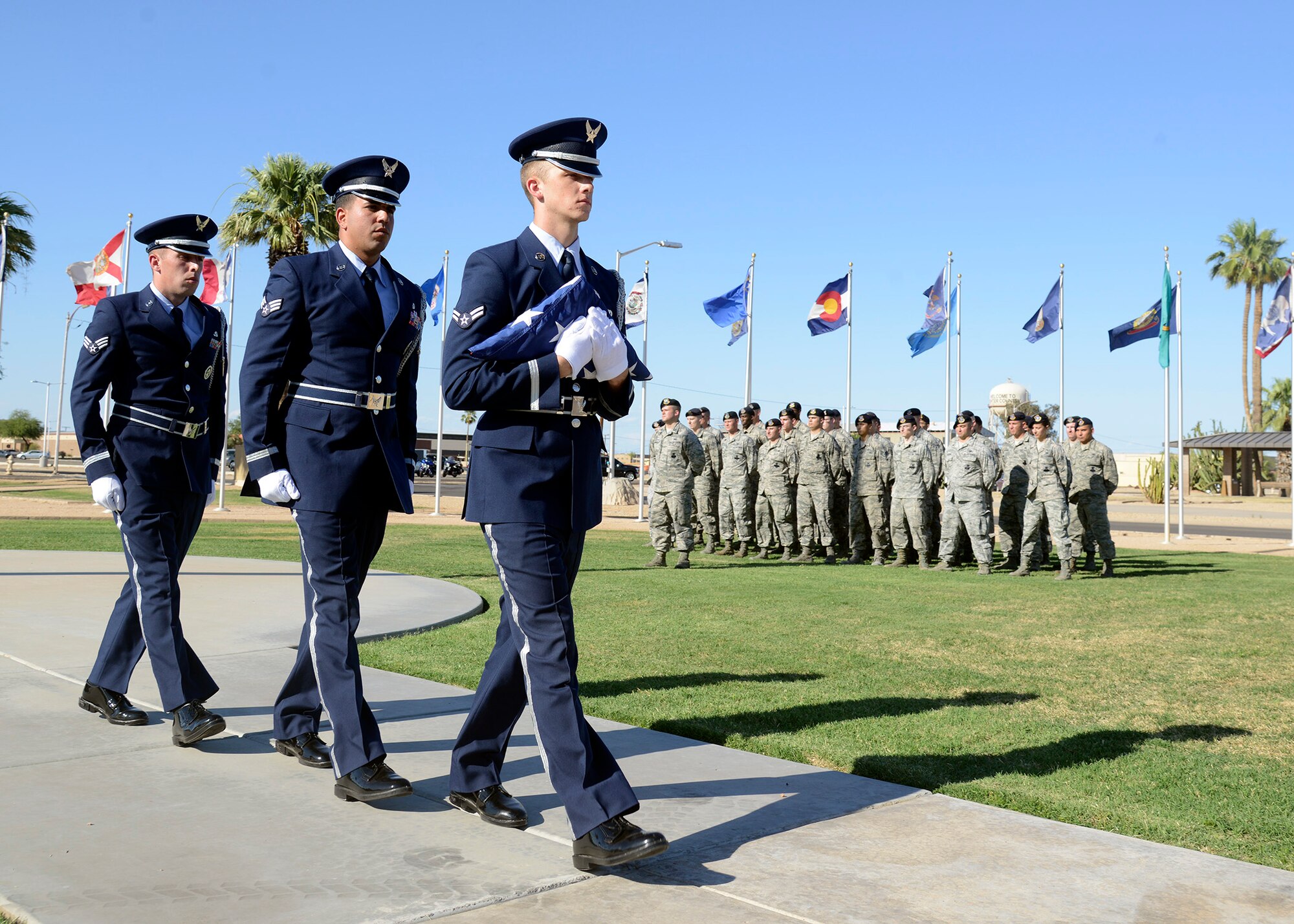 Squadron stand at parade rest as members of the Luke Air Force Base Honor Guard perform retreat during the S.S. Mayaguez Memorial Retreat Ceremony May 19, 2016 at Luke Air Force Base, Ariz. Every year police departments and law enforcement agencies come together to honor and remember those who have served our communities and those who made the ultimate sacrifice. (U.S. Air Force photo by Senior Airman Devante Williams)