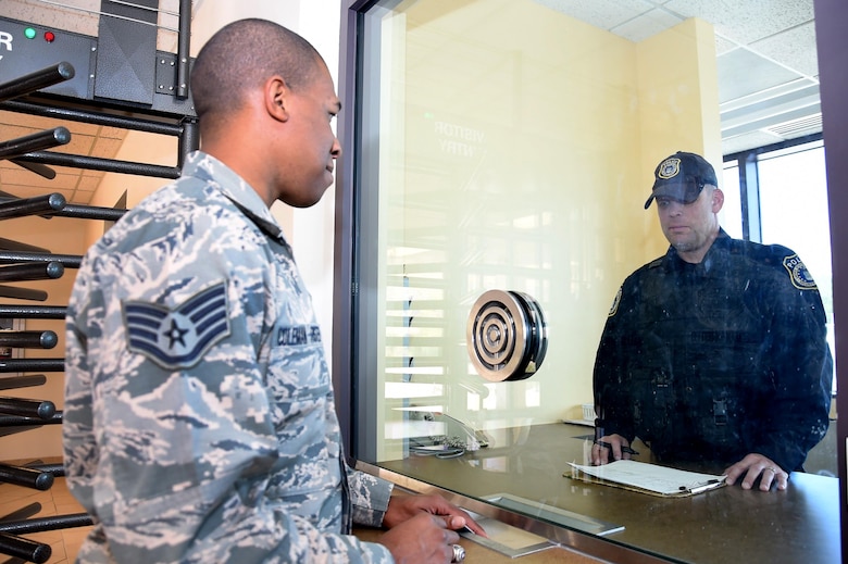 Staff Sgt. Matthew Coleman-Foster, 50th Space Wing, speaks to Officer Dean Porter, 50th Security Forces Squadron entry controller, about restricted area badging at Schriever Air Force Base, Colorado, Friday, May 20, 2016. On Aug. 1, 2016, the 50 SFS restricted area visitor badging office will relocate to the north entry control facility. (U.S. Air Force photo/2nd Lt. Darren Domingo)