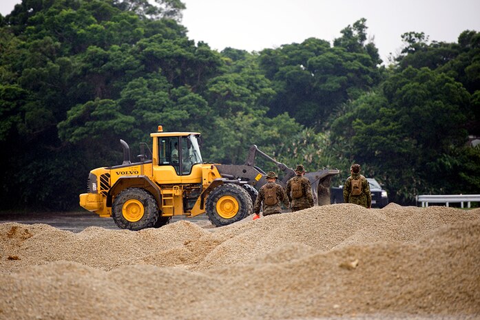 U.S. Marine Corps Marines observe Airmen operating heavy equipment during a two day joint airfield damage repair exercise May 18, 2016 at Kadena Air Base, Japan. Airmen demonstrated the method and technique the U.S. Air Force uses for airfield damage repair the first day of the exercise and the Marines applied those techniques during the second day. 