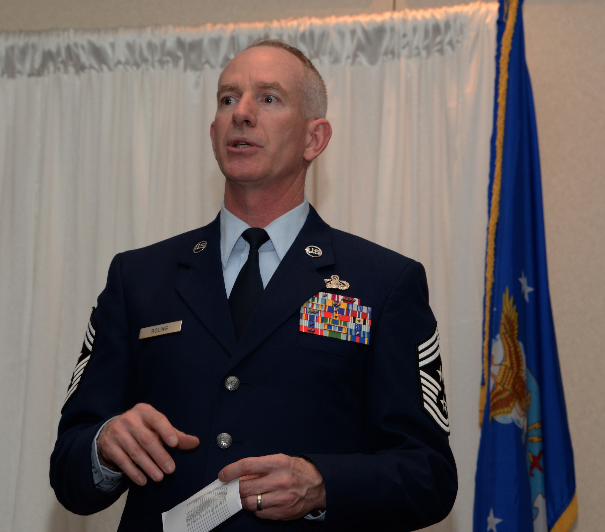 Chief Master Sgt. Alan Boling, 60th Air Mobility Wing command chief, addresses audience members during the annual Officers' and Enlisted Spouses' Clubs Military Dependent Scholarship Award ceremony May 22, 2016, at Travis Air Force Base, Calif. Nineteen scholarships totaling $54,000 were presented during the event to high school and college students, as well as military spouses. Boling congratulated each scholarship recipient and challenged them to do their best as they pursue their goals every day. (U.S. Air Force photo by Tech. Sgt. James Hodgman)