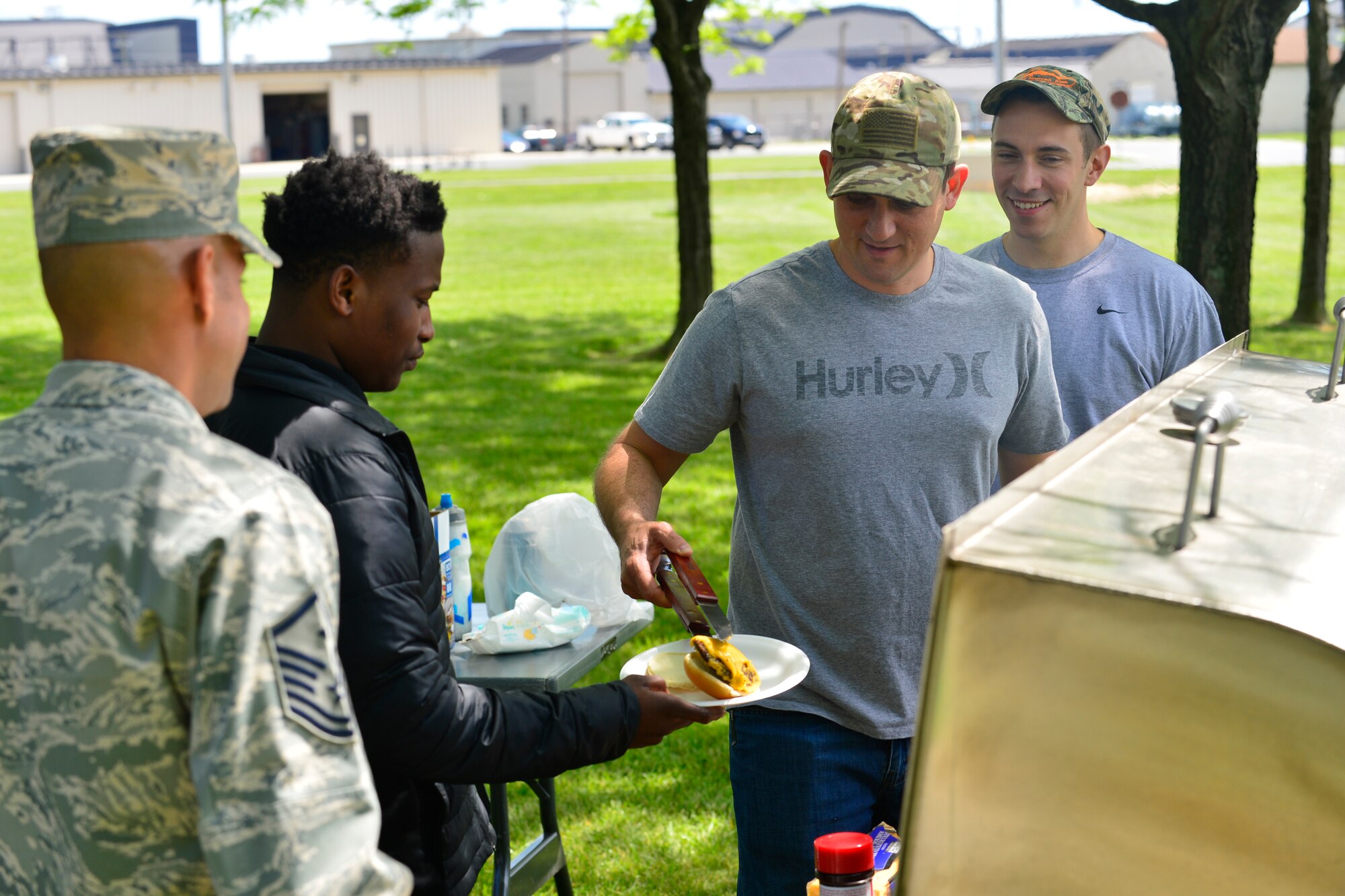Master Sgt. Jason Staggs, 9th Airlift Squadron loadmaster, serves grilled cheeseburgers and hotdogs during the last phase mentoring session for the Communities in Schools program May 19, 2016 at Dover Air Force Base, Del. This was the last meeting for the school year between Team Dover mentors and their high school mentees. (U.S. Air Force photo/Senior Airman William Johnson)