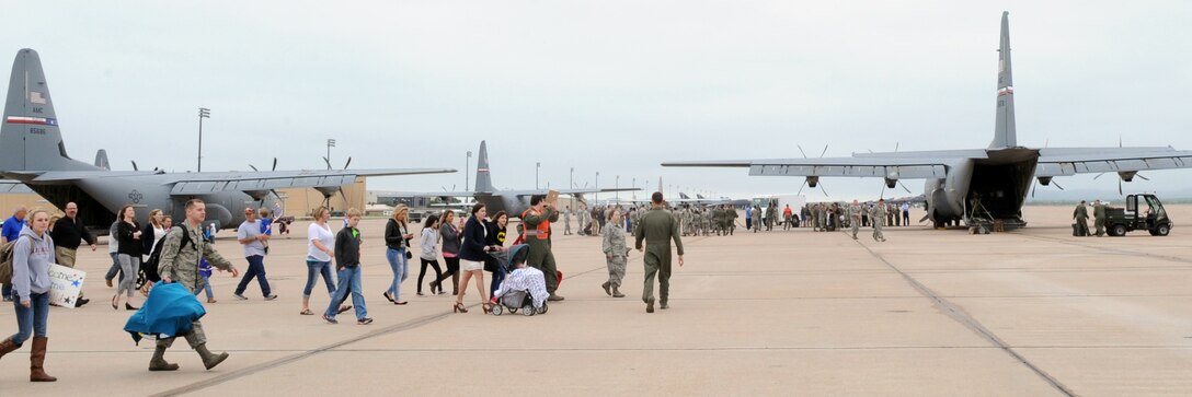 Families and friends walk onto the flightline to welcome home Airmen assigned to the 317th Airlift Group May 19, 2016, at Dyess Air Force Base, Texas. More than 200 Airmen were deployed supporting various operations within three different areas of responsibility. (U.S. Air Force photo by Senior Airman Shannon Hall/Released)