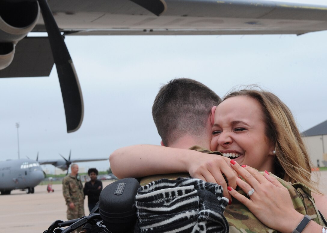 U.S. Air Force 1st Lt. Jesse Behning, 40th Airlift Squadron pilot, hugs his crying wife, Lena, May 19, 2016, at Dyess Air Force Base, Texas. More than 200 Airmen, from the 317th Airlift Group, made up nine air crews operating six C-130J Super Hercules’ for a four month deployment. (U.S. Air Force photo by Senior Airman Shannon Hall/Released)