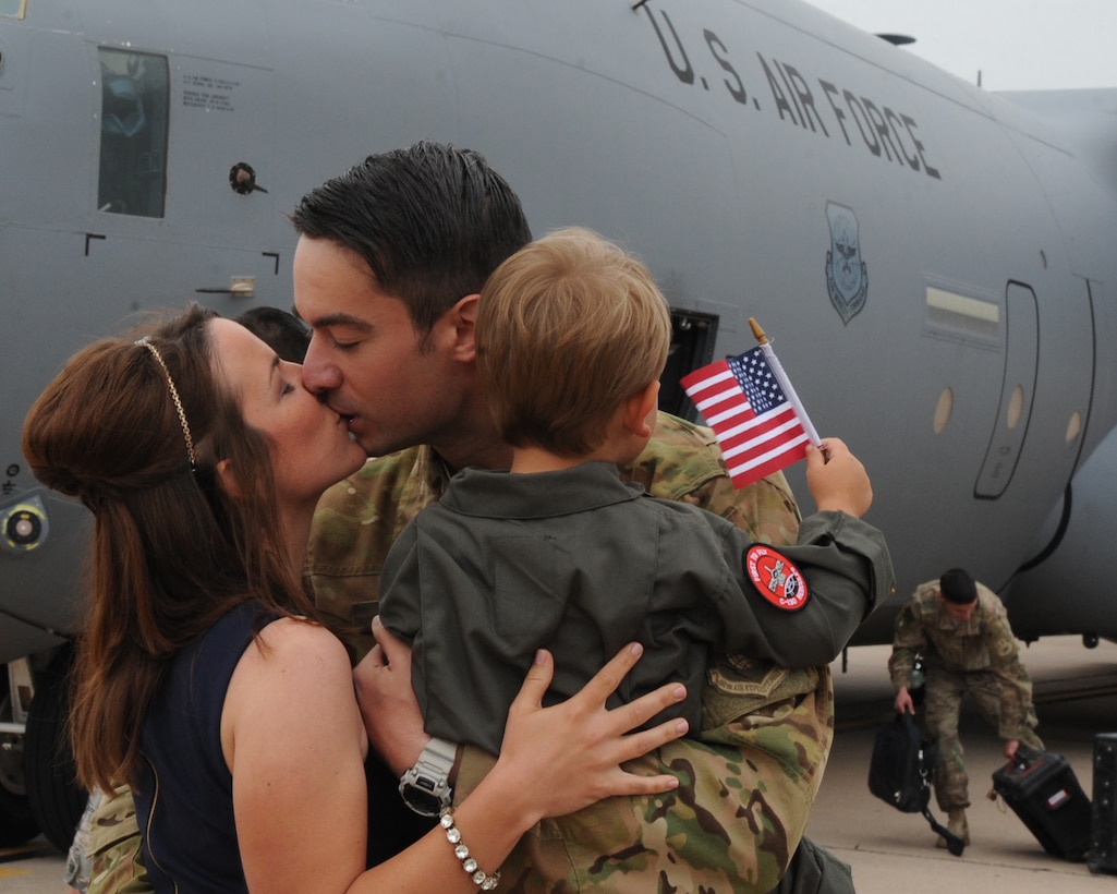 U.S. Air Force Capt. Nathan Hering, 40th Airlift Squadron pilot, kisses his wife, Laura, May 19, 2016, at Dyess Air Force Base, Texas. Hering was deployed with more than 200 other Airmen assigned to the 317th Airlift Group. The Airmen transported 13,000 passengers, 10,000 tons of cargo and 130 aeromedical evacuation patients during their four month deployment. (U.S. Air Force photo by Senior Airman Shannon Hall/Released)