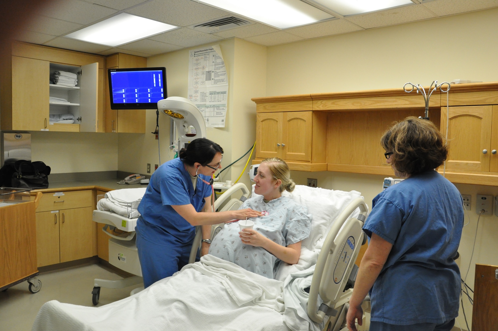 A1C Hannah Mahler simulates an expectant mother by using the MCCF simulation belly, while Capt. Krisha Prentice, R.N. and Capt. Laura Nowlin, R.N. help demonstrate the care mother and baby receive while admitted.