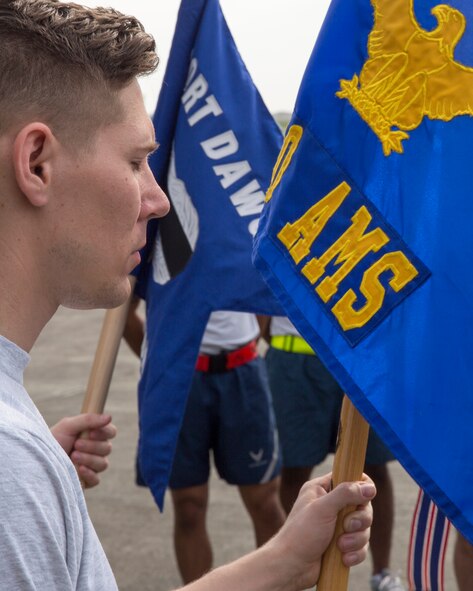 Senior Airman Michael Graves, 730th Air Mobility Squadron air freight supervisor, mourns the fallen Airmen during the moment of silence at Yokota Air Base, Japan, May 20, 2016. The 730 AMS hosted the 3rd annual Port Dawg Memorial 5K Run for the fallen Airmen in the Air Transportation career field in the past. (U.S. Air Force photo by Yasuo Osakabe/Released)    