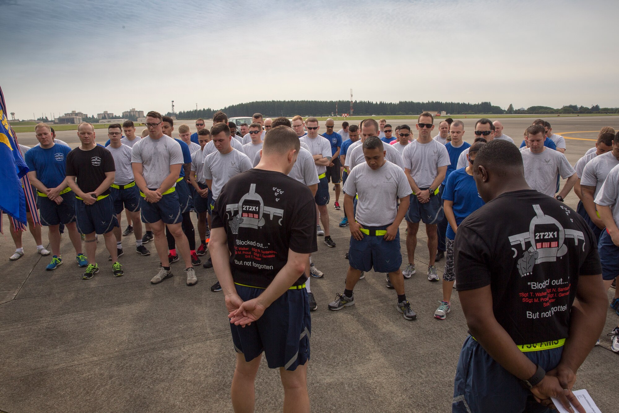 Airmen from the 515th Air Mobility Operations Group, 730th Air Mobility Squadron and 374th Logistics Readiness Squadron bow their heads during a moment of silence during the Port Dawg Memorial 5K Run at Yokota Air Base, Japan, May 20, 2016. The 730 AMS hosted the annual memorial run for the fallen Airmen in the Air Transportation career field in the past. (U.S. Air Force photo by Yasuo Osakabe/Released)     