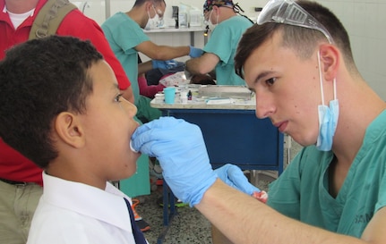 U. S. Army Spc. Tyler Novich, Joint Task Force-Bravo Medical Element dental specialist, cares for a pediatric patient after a molar extraction in the Catholic University, Tegucigalpa, Honduras, May 6, 2016. A total of 208 pediatric patients between the ages of 2 and 16 were seen during the two-week mission in the Honduran capital. (U.S. Army photo by 1st Lt. Jenniffer Rodriguez)