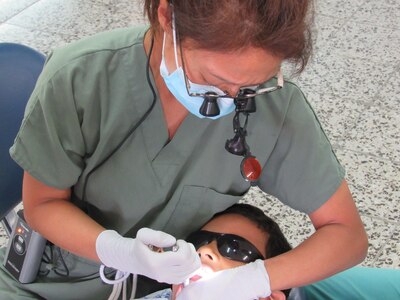 U.S. Army Maj. (Dr.) Margaret Novicio, Joint Task Force-Bravo Medical Element dentist, performs a molar extraction on a pediatric patient in the Catholic University, Tegucigalpa, Honduras, May 6, 2016. MEDEL supported U.S. Army Dental Command and U.S. Southern Command during pediatric dental humanitarian assistance projects in Tegucigalpa May 3-12. (U.S. Army photo by 1st Lt. Jenniffer Rodriguez)