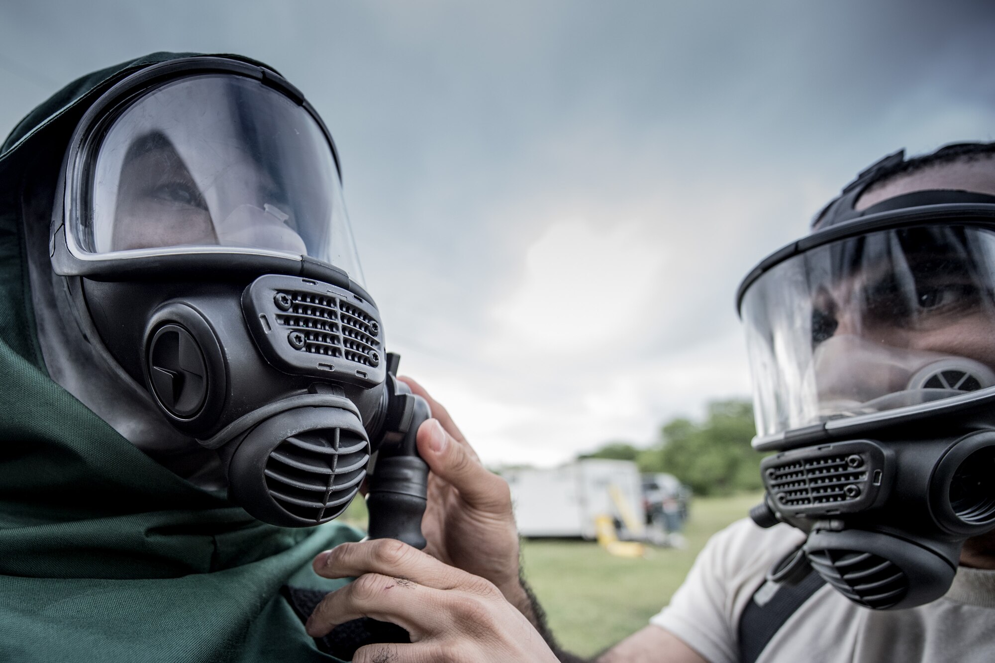 1st Lt. Lenton Johnson, 149th Force Support Squadron, Texas Air National Guard, headquartered at Join Base San Antonio-Lackland, waits while Tech. Sgt. Edwin Bello, also 149th FSS, adjusts his chemical protective mask at JBSA-Lackland, Texas, April 10, 2016. These airmen are members of the 149th FSS Fatality Search and Recovery Team. These FSRT members are training on how to move into a contaminated area and recover remains after a chemical disaster. (U.S. Air National Guard photo by Tech. Sgt. Eric L. Wilson)
