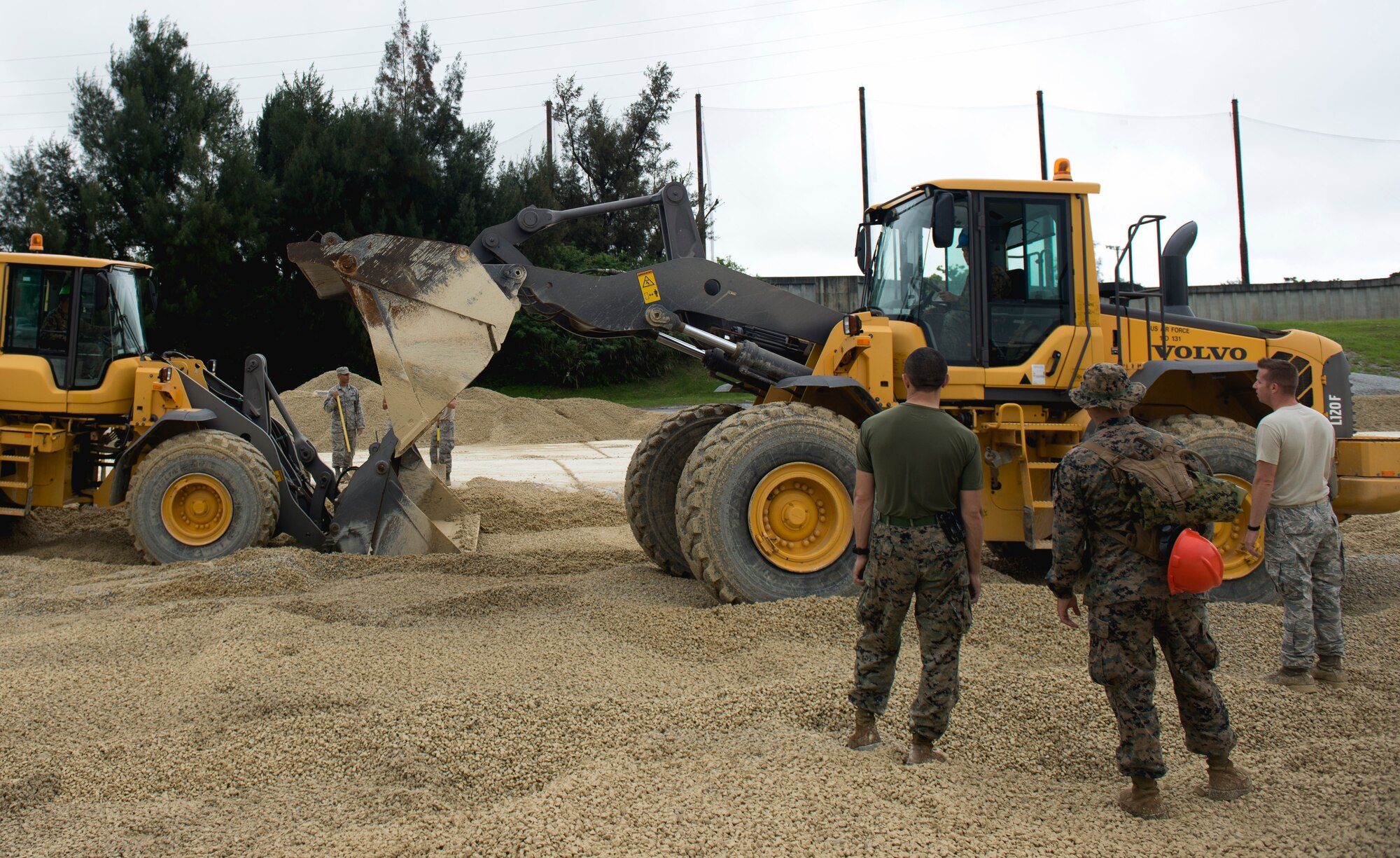 Marines fill a 50-foot crater during a two day joint airfield damage repair exercise May 18, 2016 at Kadena Air Base, Japan. 18th Civil Engineer Squadron Airmen taught Marine Wing Support Squadron combat engineers how the U.S. Air Force performs ADR. (U.S. Air Force photo by Senior Airman Omari Bernard)