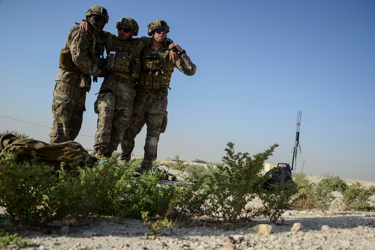 Master Sgt. Thomas Dennis, 379th Expeditionary Civil Engineer Squadron first sergeant, and Tech. Sgt. David Dickey, 379th ECES explosive ordnance disposal craftsman, escort Staff Sgt. Darrel Linkus, also a 379th ECES EOD craftsman, to a simulated medical evacuation helicopter during a training exercise May 19, 2016, at Al Udeid Air Base, Qatar. EOD Airmen as assigned to some of the most dangerous missions where they tactically perform harrowing and demanding task in diverse environments in theater. (U.S. Air Force photo/Senior Airman Janelle Patiño/Released)