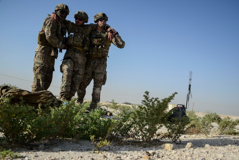 Master Sgt. Thomas Dennis, 379th Expeditionary Civil Engineer Squadron first sergeant, and Tech. Sgt. David Dickey, 379th ECES explosive ordnance disposal craftsman, escort Staff Sgt. Darrel Linkus, also a 379th ECES EOD craftsman, to a simulated medical evacuation helicopter during a training exercise May 19, 2016, at Al Udeid Air Base, Qatar. EOD Airmen as assigned to some of the most dangerous missions where they tactically perform harrowing and demanding task in diverse environments in theater. (U.S. Air Force photo/Senior Airman Janelle Patiño/Released)